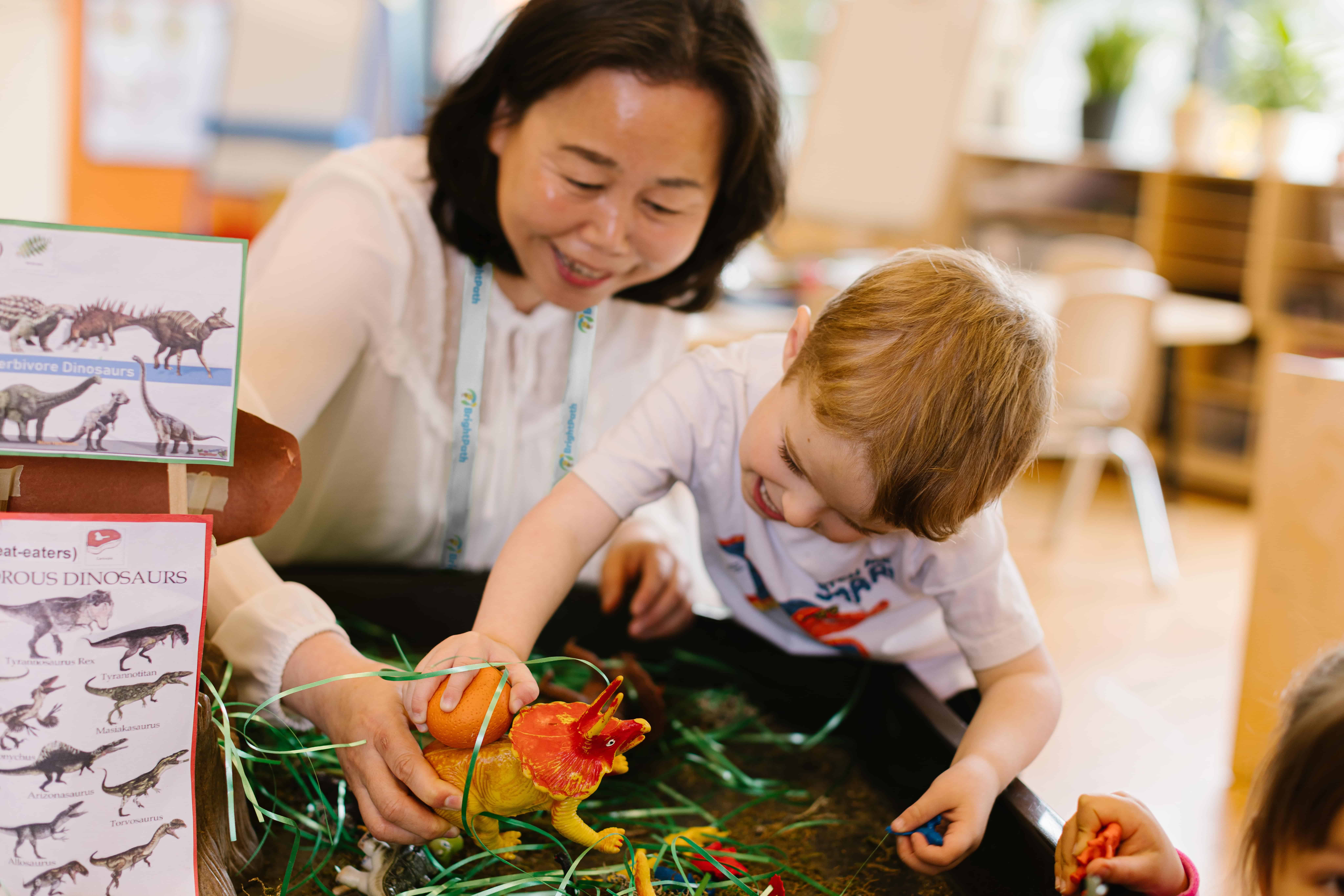 Early childhood educator assisting a child during learning activities